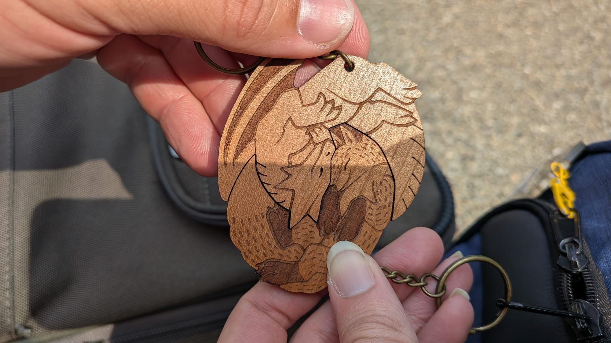 Two wooden keychains of a fox and dragon that interlock with each other.